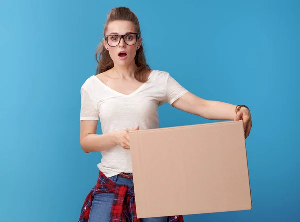 惊奇现代时髦在白色衬衣与一个纸板盒被隔绝在蓝色背景上 — 图库照片
