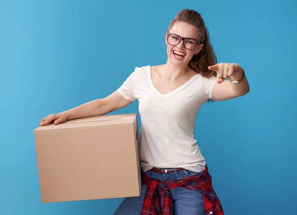 Sonriente Joven Hipster Camisa Blanca Con Una Caja Cartón Apuntando —  Fotos de Stock