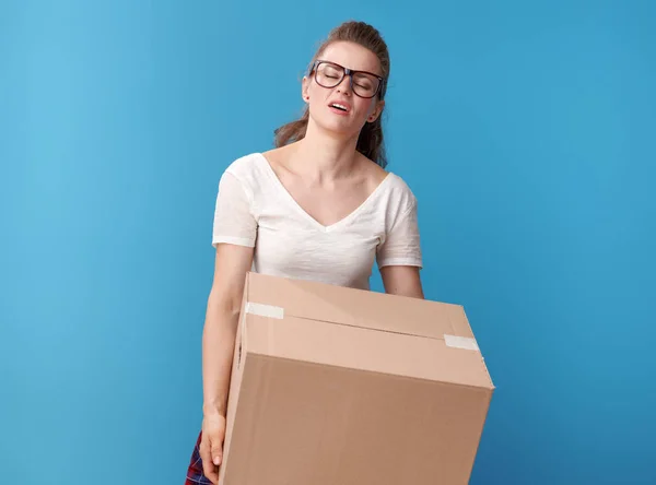 青の背景に分離された段ボール箱と白いシャツの疲れている現代の女性の肖像画 — ストック写真