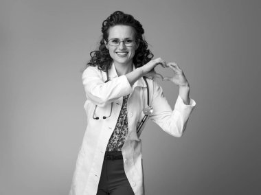 kalp gösterilen beyaz tıbbi elbise içinde gülümseyen çocuk doktoru Doktor eller şeklinde