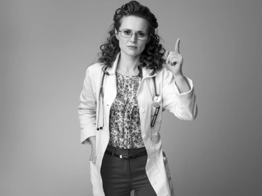 Çocuk doktoru Doktor yükseltilmiş bir parmak ile beyaz tıbbi elbise içinde