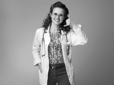 Çocuk doktoru Doktor arama gösterilen beyaz tıbbi elbise içinde gülümseyerek bana jest