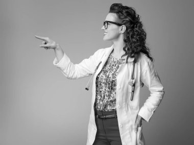 mutlu çocuk doktoru Doktor bir şeye işaret eden beyaz tıbbi elbise içinde