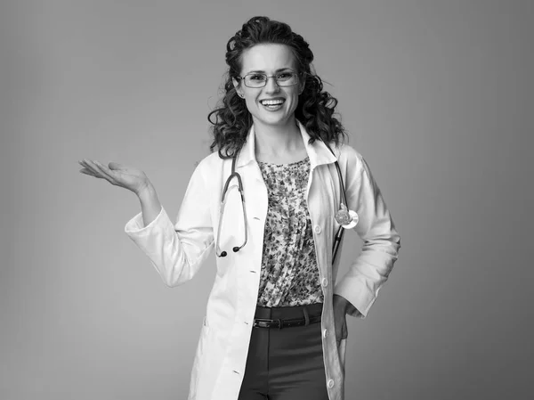 Usmívající Žena Pediatr Bílé Lékařské Roucho Ukazuje Něco Prázdné Dlaně — Stock fotografie
