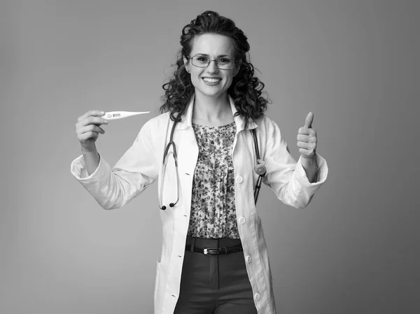 Leende Barnläkare Kvinna Vit Medicinsk Dräkt Visar Tummen Och Termometer — Stockfoto