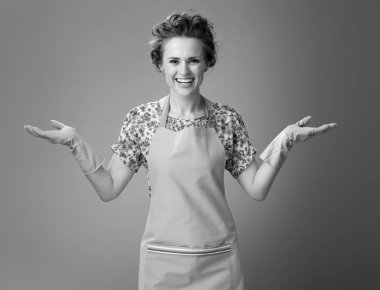 mutlu genç kadın bir şey boş avucunda sunan bir önlük