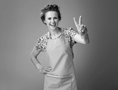 gülümseyen bir önlük zafer jest gösterilen modern kadın