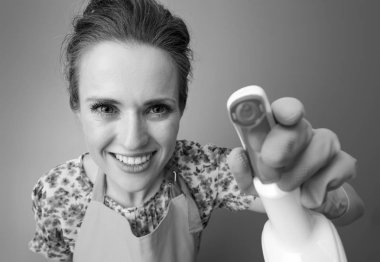 gülümseyen bir önlük temizlik deterjan kullanarak modern kadın