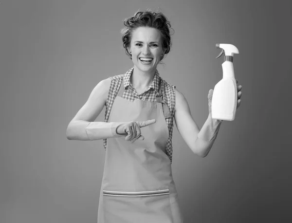 Happy Modern Housewife Apron Pointing Bottle Detergent — Stock Photo, Image