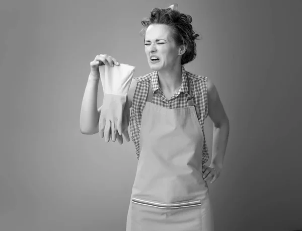 Sad Young Housewife Apron Sniffing Rubber Gloves — Stock Photo, Image