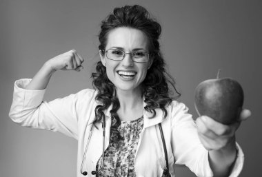 mutlu paediatrist kadın bir elma veren ve üzerinde izole pazı gösterilen beyaz tıbbi elbise içinde