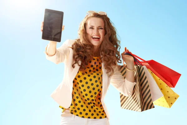 Happy Modern Woman Light Jacket Shopping Bags Showing Tablet Blank — Stock Photo, Image