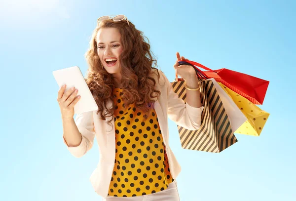 Überraschte Trendige Frau Heller Jacke Mit Einkaufstüten Vor Blauem Himmel — Stockfoto