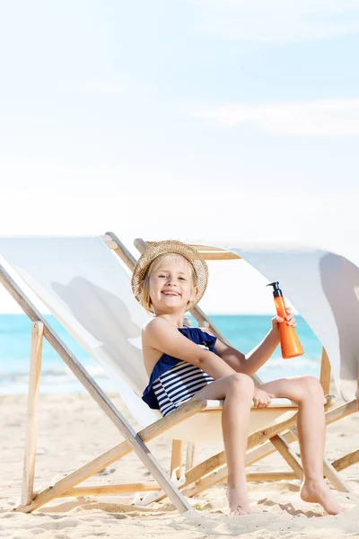 Happy Little Girl Swimwear Seacoast Sitting Beach Chair Holding Sunscreen — Stock Photo, Image