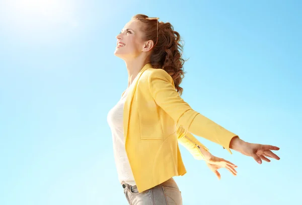 Sonriente Joven Chaqueta Amarilla Regocijándose Contra Cielo Azul —  Fotos de Stock