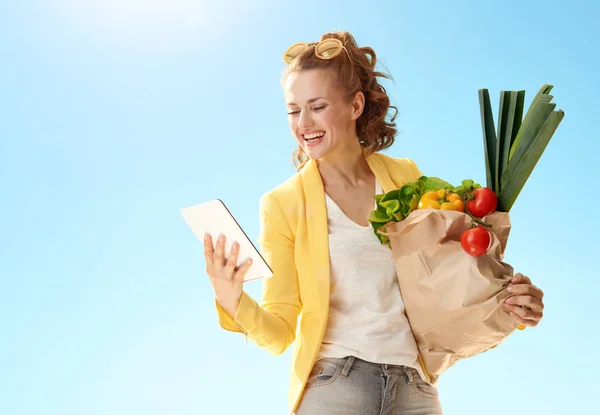 Femeie Fericită Modă Jachetă Galbenă Pungă Hârtie Alimente Folosind Tabletă — Fotografie, imagine de stoc