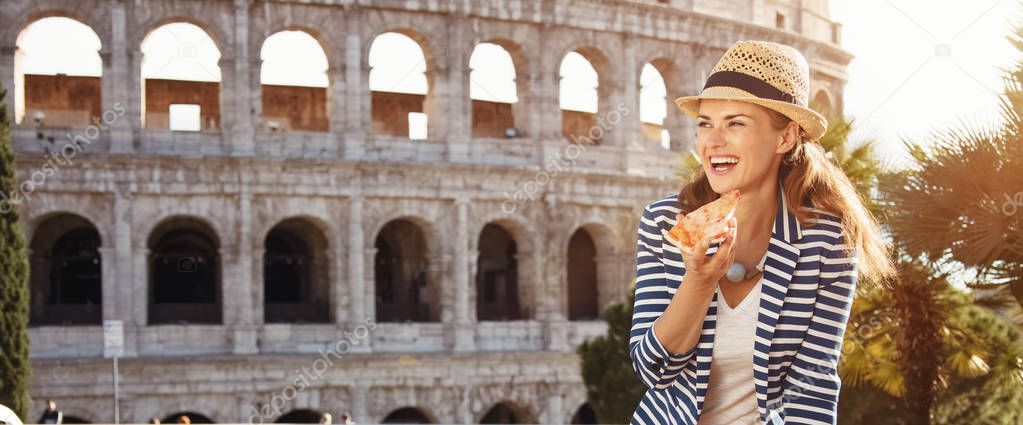 smiling young woman in a straw hat in Rome, Italy with pizza