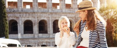 Anne ve çocuk turistler önünde pizza yemek Colosseum