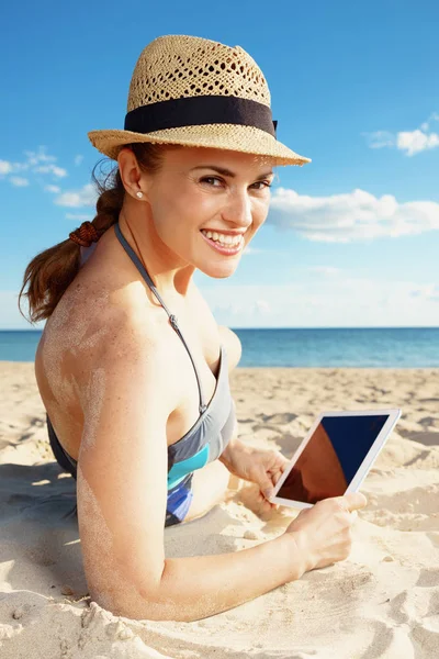 快乐的现代妇女泳装与平板电脑在海边 — 图库照片