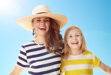 Genç Anne ve çocuk mavi gökyüzü gülümseyen portresi