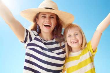 Modern anne ve çocuk karşı mavi gökyüzü sevindirici gülümseyen