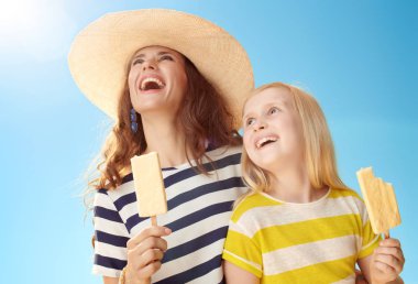 Genç Anne ve çocuk dondurma kopya alanı mavi gökyüzü karşı bakarak bir sopa ile gülümseyen