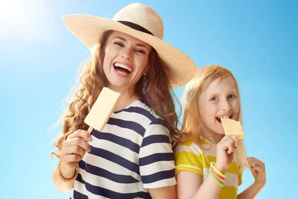 快乐的现代母亲和孩子吃冰淇淋对蓝天 — 图库照片