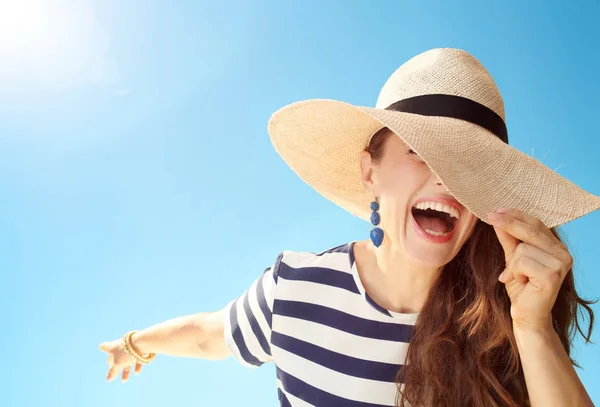 ストロー ハット麦わら帽子の後ろに隠れて青い空を背景にスタイリッシュな女性の幸せ — ストック写真