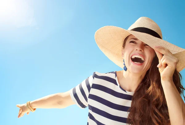 麦わら歓喜とコピー領域を見て青い空を背景にスタイリッシュな女性を笑顔 — ストック写真
