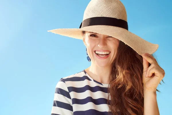 青い空を背景に麦藁帽子でスタイリッシュな女性を笑顔 — ストック写真