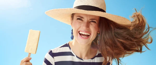 青空アイス棒を麦藁帽子の陽気な現代の女性 — ストック写真