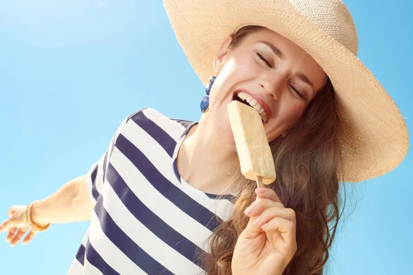 Glimlachend Stijlvolle Vrouw Stro Hoed Tegen Blauwe Hemel Eten Van — Stockfoto