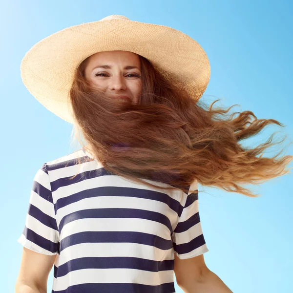 Glimlachend Moderne Vrouw Stro Hoed Met Fladderende Haren Tegen Blauwe — Stockfoto