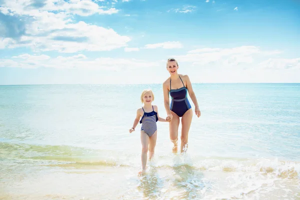 Happy Moderní Matka Dítě Plavkách Vycházející Moře Pláži — Stock fotografie