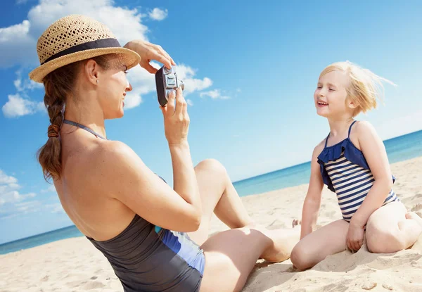 水着ビーチで写真のレトロなフィルム カメラで写真を撮っては若い母と子の笑顔 — ストック写真