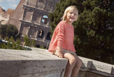 parapet Kolezyum, Roma, İtalya, yakın oturan mutlu trendy çocuk 
