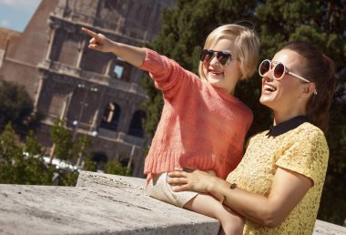 mutlu son moda anne ve kızı gezginler bir kenara Roma, İtalya, Colosseum civarındaki işaret