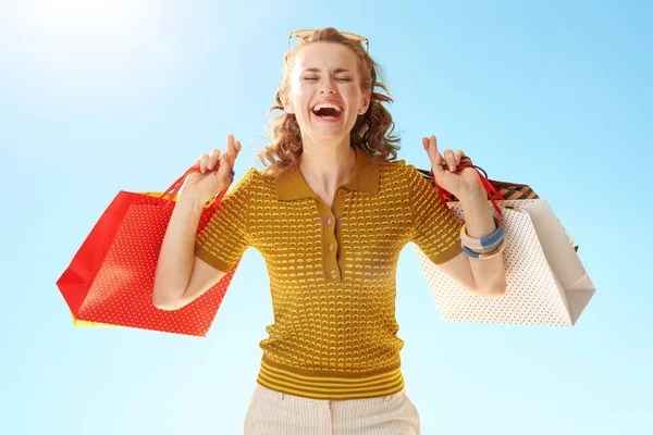 Smiling Trendy Woman Shopping Bags Crossed Fingers Blue Sky — Stock Photo, Image