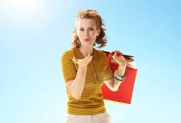 Счастливая Привлекательная Женщина Пакетами Покупок Дуть Воздушный Поцелуй Против Голубого — стоковое фото