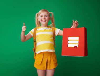 yukarı ve ileti örneği ile alışveriş çantası yeşil arka plan üzerinde gösterilen sırt çantası ile mutlu okul kız