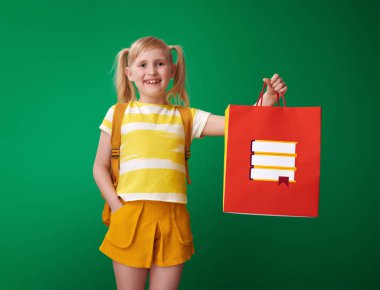 ileti örneği ve kameraya yeşil arka plan üzerinde seyir ile alışveriş çantası gösterilen sırt çantası ile öğrenci gülümseyen