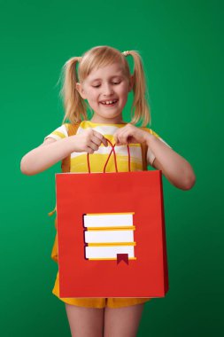 ileti örneği arka planı yeşil karşı ile alışveriş çantası içinde seyir sırt çantası ile öğrenci gülümseyen 