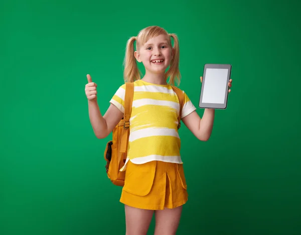 Smilende Skole Pige Med Rygsæk Viser Tommelfinger Holde Tablet Blank - Stock-foto