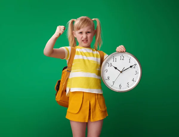 Genervte Schülerin Mit Rucksack Hält Uhr Auf Grünem Hintergrund — Stockfoto