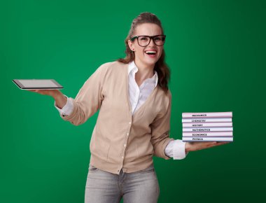 mutlu genç öğrenci kadın kitap ve tablet Pc gösteren yeşil zemin üzerine teknolojinin kolaylığı ile