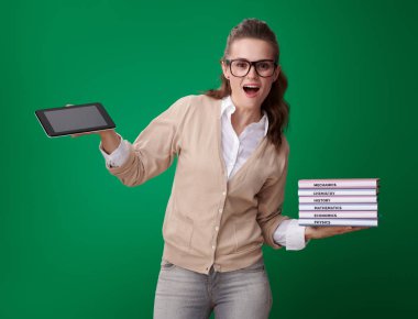 şok genç öğrenci kadın kitap ve tablet Pc gösteren yeşil zemin üzerine teknolojinin kolaylığı ile