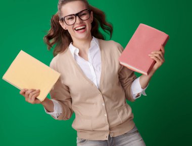 çekici genç öğrenci kadın gözlük yeşil arka plan kitapları ile