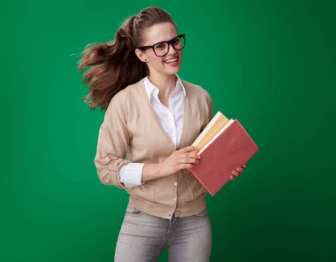 mutlu genç öğrenci kadın gözlük yeşil zemin üzerine kitaplar holding