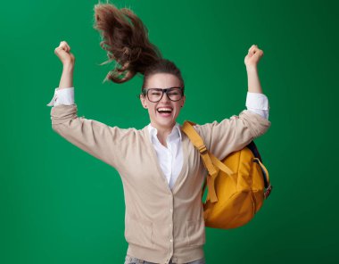 atlama ve yeşil arka plan üzerinde sevindirici gülümseyen modern öğrenci kadın