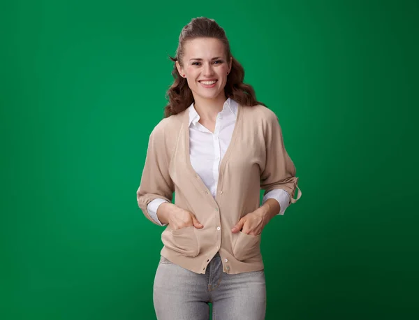 Uśmiechnięty Młody Student Kobieta Trzymając Ręce Kieszenie Patrząc Kamery Zielonym — Zdjęcie stockowe
